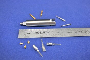 micro parts made on a milling machine next to a ruler